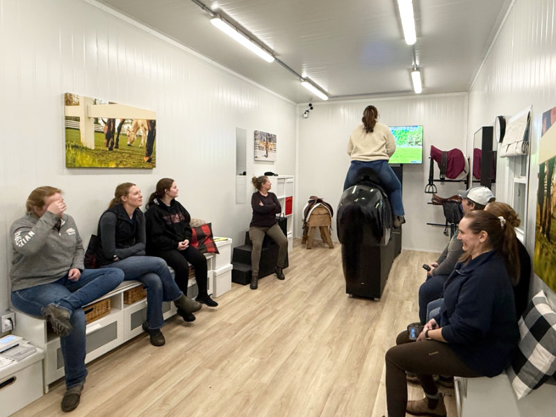 Barn party - group enjoying learning on horse simulator Will-oh!