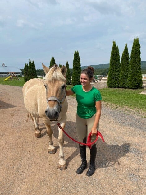 Riser leads her horse at Willow and Withers Stables, Sheffield Mills, Nova Scotia